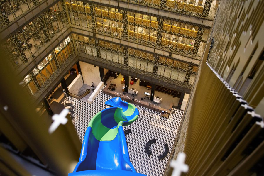 Bobst Library is NYU’s hub for studying and research. Its main atrium is a sight to behold that ought to be graced with a slide. (Staff Photo by Luca Richman, Staff Illustration by Susan Behrends Valenzuela)