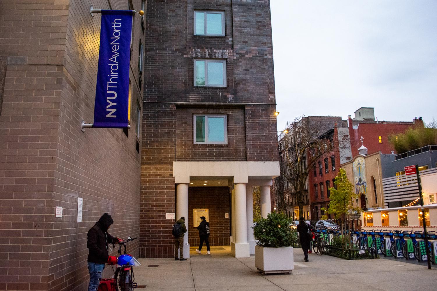 A brown brick building with a purple blag reading "N.Y.U. Third Ave North."