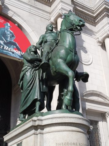 A bronze sculpture depicting Theodore Roosevelt riding a horse. On one side stands an indigneous person and on the other side stands a Black person.
