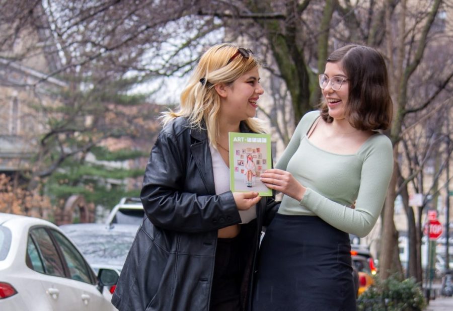 A+portrait+of+Natalia+Palacino+and+Susan+Behrends+Valenzuela+reading+a+zine.+Palacino+is+wearing+a+black+leather+coat+while+Behrends+Valenzuela+wears+a+mint-green+long-sleeve+shirt+and+a+black+skirt.