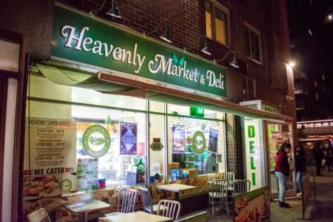The exterior façade of the store, Heavenly Market & Deli, with its green and white logo on the storefront.