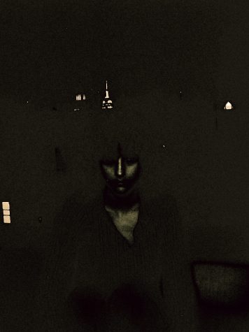 A shadowy figure in gray darkness; tower glows behind.