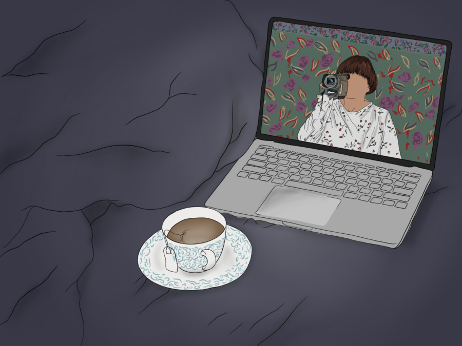 An illustration of a computer on the right of a bed with a blue blanket. The computer screen displays a woman wearing a white shirt and holding a video camera. In front of the computer there is a small teacup.