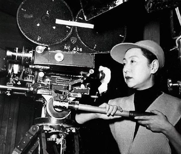 A+black-and-white+picture+of+director+and+actress+Kinuyo+Tanaka+holding+a+movie+camera.