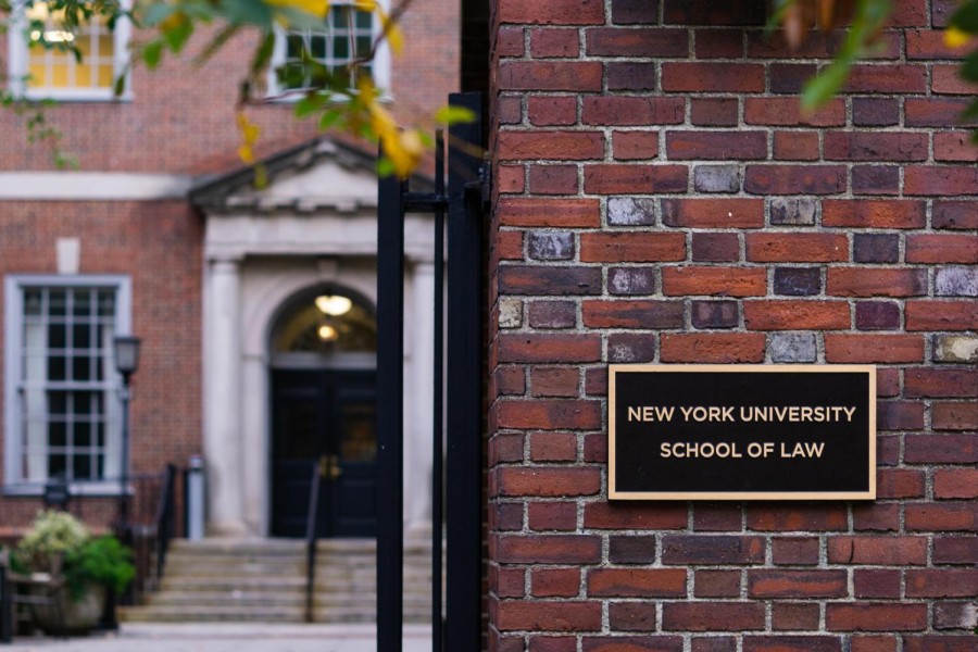 The brick column in front of the NYU law school with a plaque saying “New York University School of Law.”