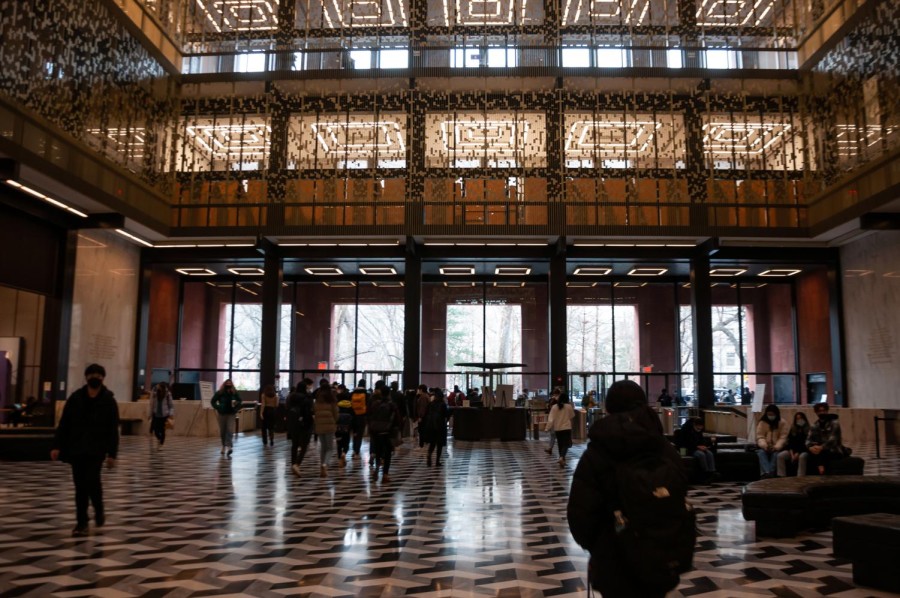 The atrium of Bobst Library as seen from its lobby. Visitors walk in and out of the building.