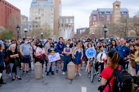 Protesters gathered around the fountain at Washington Square Park holding signs and loudspeakers.