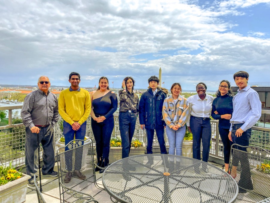 Nine attendees, one professor and nine students, of the Groom Law Group event stand on a balcony.