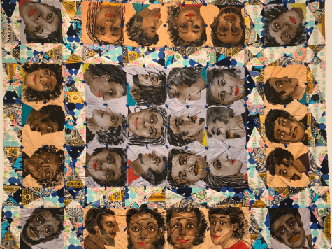 A quilt with squares of painted faces, each positioned at different angles. Interspersed within the pattern of faces is a multicolored, predominantly blue and white pattern that features prints assorted in a collage.