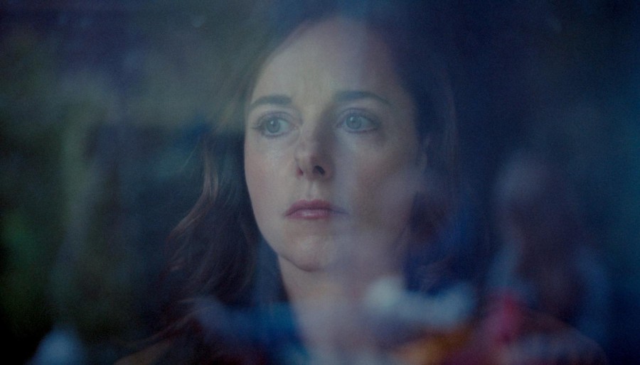 A+still+from+the+film+of+a+woman+looking+ahead+through+a+glass+surface.+She+is+wearing+makeup+but+looks+tired+and+lost.