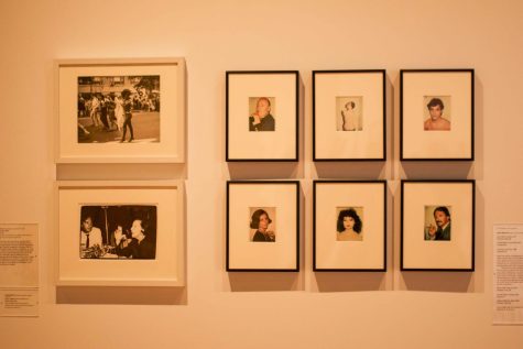 Two white photo frames are next to six black photo frames with images displayed within at the Grey Art Gallery.