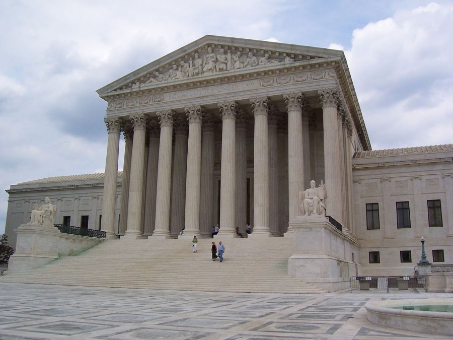The marble facade of the building of the U.S. Supreme Court. The building has eight columns and marble stairs.