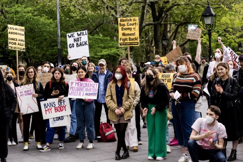 People hold signs at an abortion rights protest in Washington Square Park. Signs include "Legalize abortion once and for all," "We will not go back," and "My body my choice."