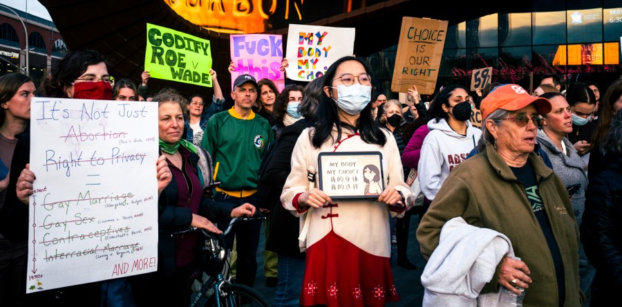 People hold signs at an abortion rights protest at Barclays Center. Signs read Codify Roe v. Wade, Fuck this, and Its not just abortion: Right to privacy equals gay marriage, gay sex, contraception and interracial marriage.