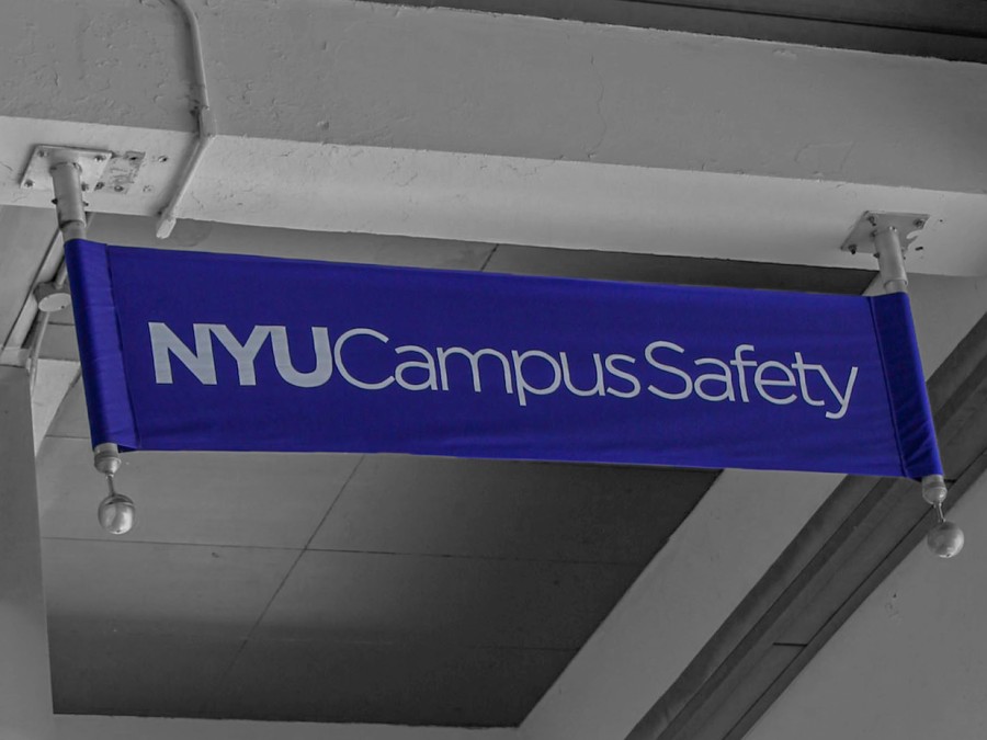 The NYU Campus Safety logo printed on a banner against a white wall.
