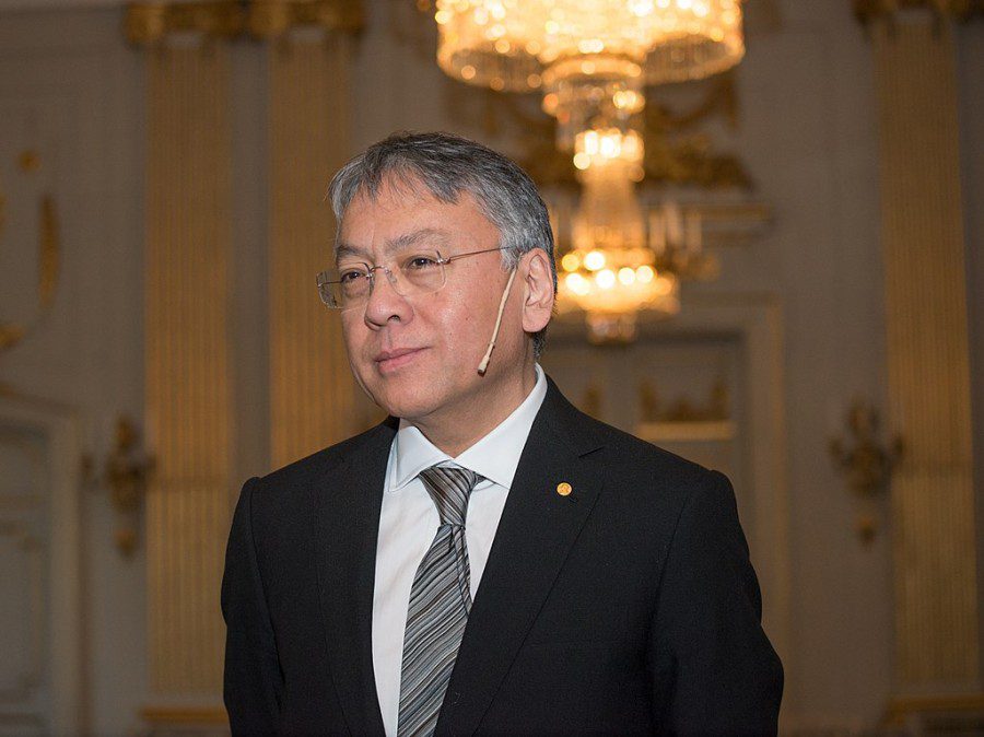 Author Kazuo Ishiguro dressed in a white shirt, silver-patterned tie and black suit in the Stockholm Stock Exchange.
