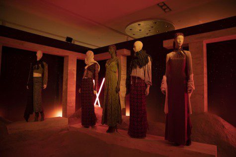 A room lit by a red light with five mannequins posing in Revolve clothes.