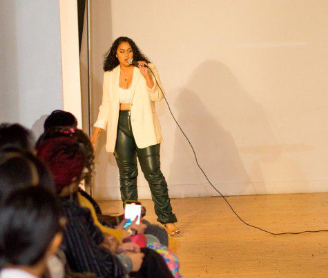 A woman holding a microphone standing in the middle of a runway.