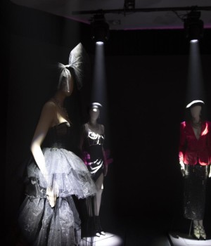 A room with three mannequins in the spotlight.