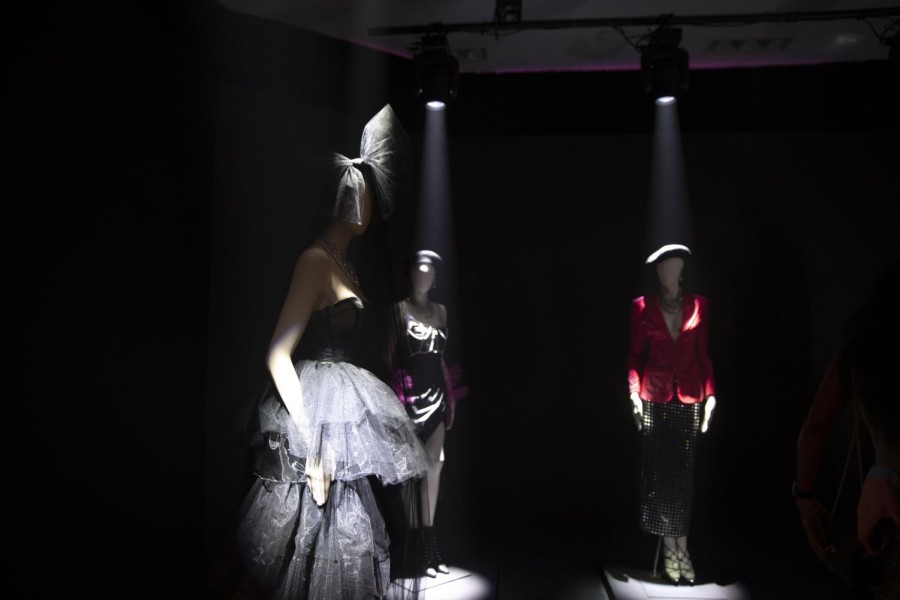 A room with three mannequins in the spotlight.