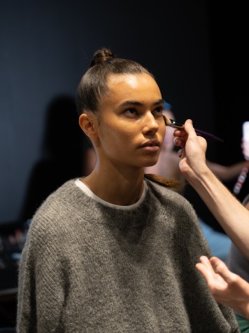Backstage model gets makeup applied.