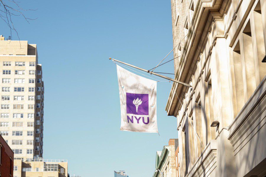 Photograph of an NYU flag hanging outside of a building.