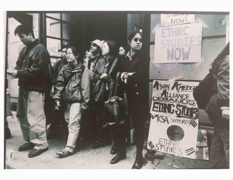 A black-and-white photo of students gathering with signs that read “ethnic studies now” and “Asian American Alliance demands ethnic studies.”