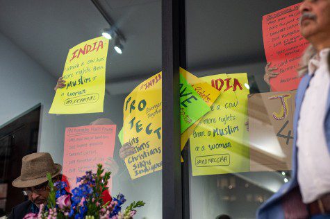 People holding yellow and red signs saying “Human Rights in India are Under Attack.”