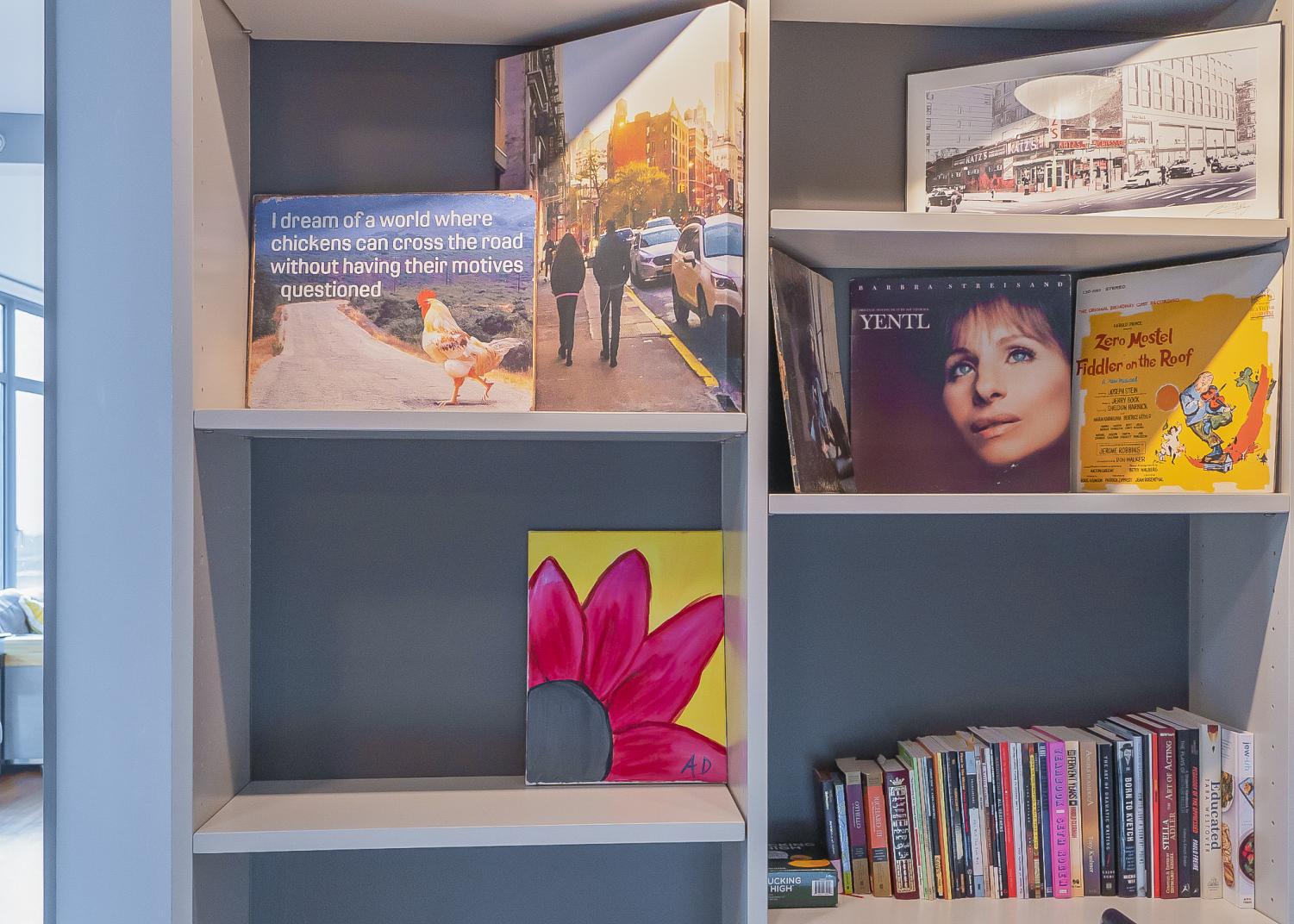 On Adora Dayani’s blue shelves are albums, books and paintings.