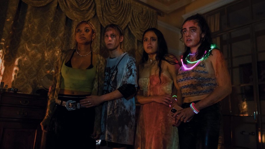 Four+female+characters+dressed+in+colorful+party+outfits+covered+in+blood+and+dirt+look+forward%2C+terrified.
