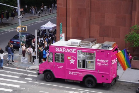 People wait in line around the corner of Bobst Library to buy food from a bright pink Garage truck.