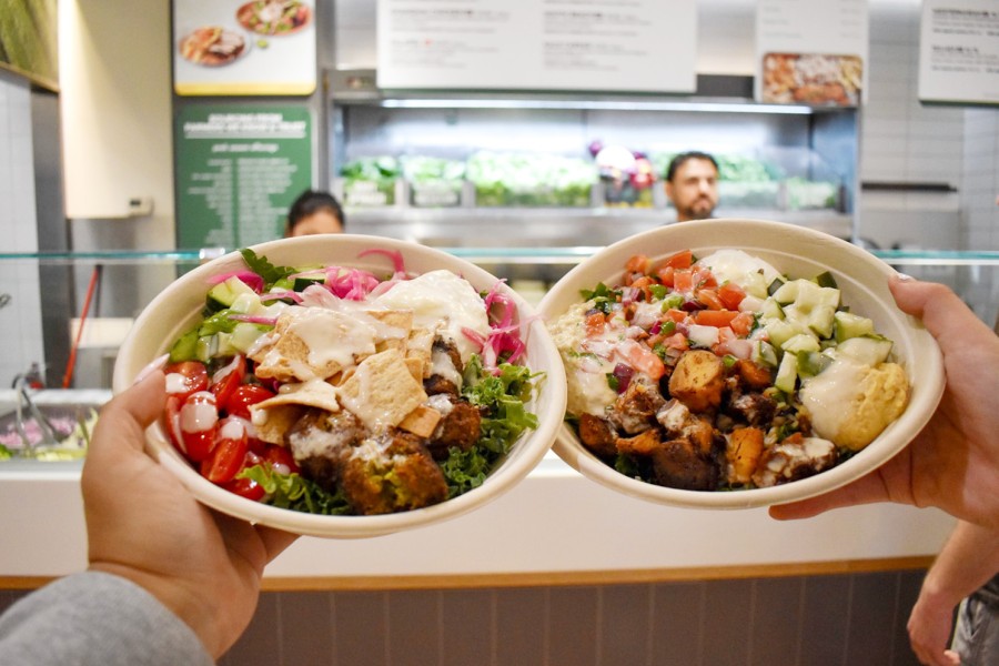 The Falafel Bowl and the Chicken Shawarma held up in front of a counter at fresh&co