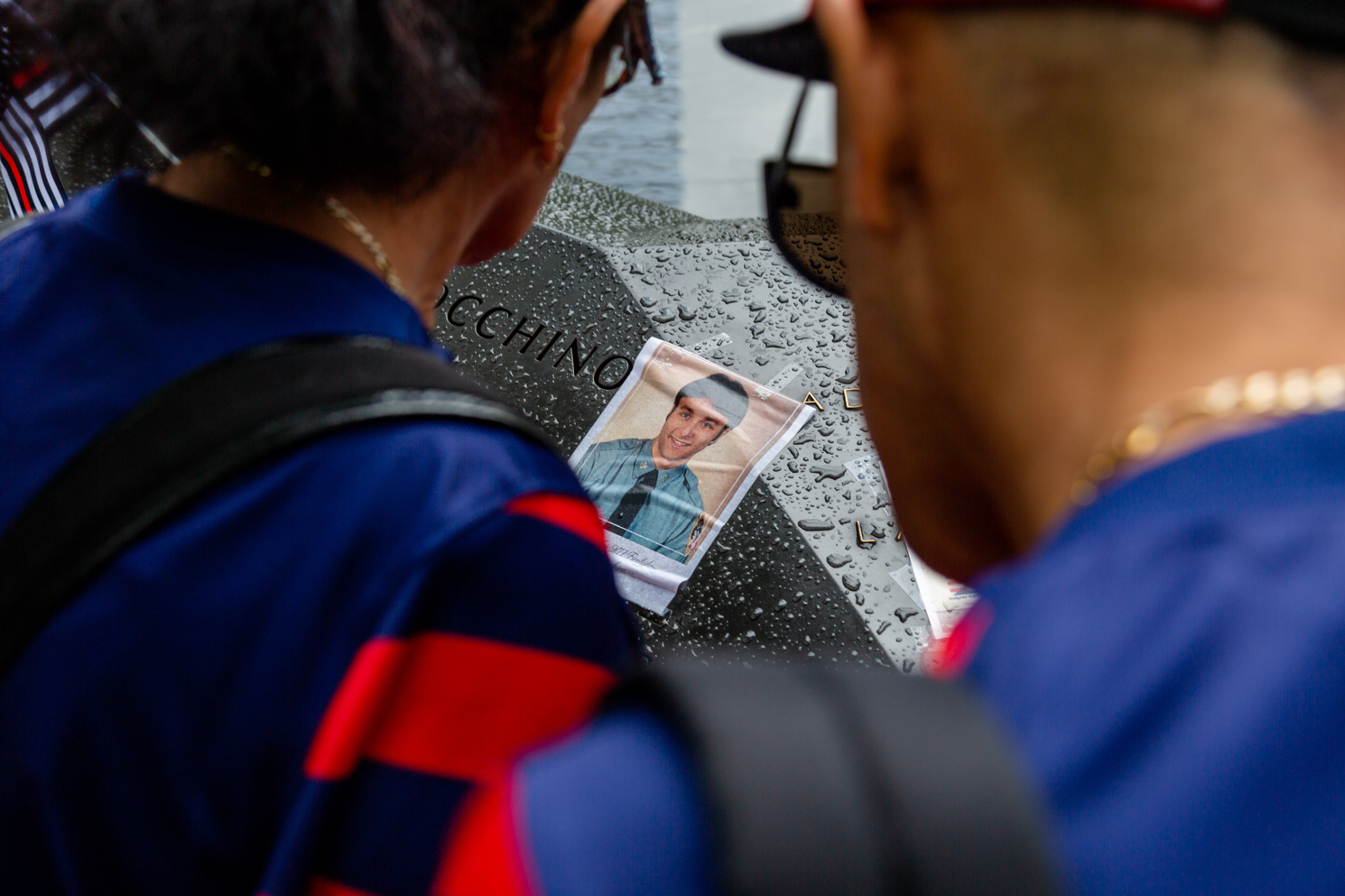 Visitors look at a photograph placed next to the engraved names at the Sept. 11 memorial.