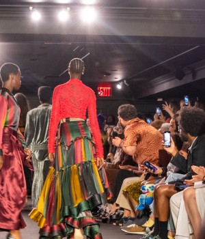 Models wearing clothes in shades of yellow, green, and red walk down anOnlyChild’s New York Fashion Week runway.