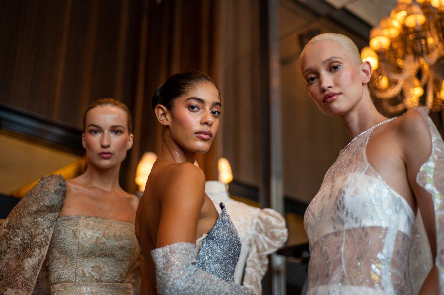 Patricia Zajacova, Anika Elle Hartje and Nadal de Vries wearing gray, silver and white dresses.