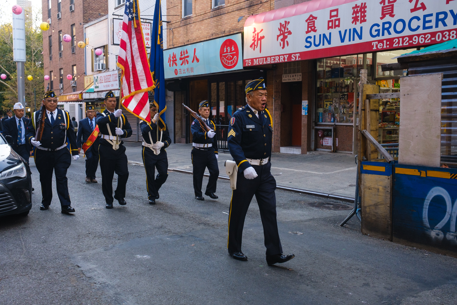 A group of Chinese Veterans dressed in military uniforms marches through Mulberry Street.