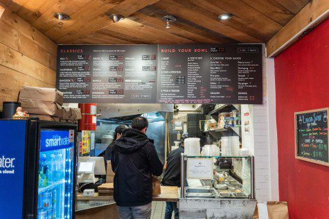 A man stands at the counter ordering food off the menu at MIGHTY Bowl, located on 120 MacDougal Street.