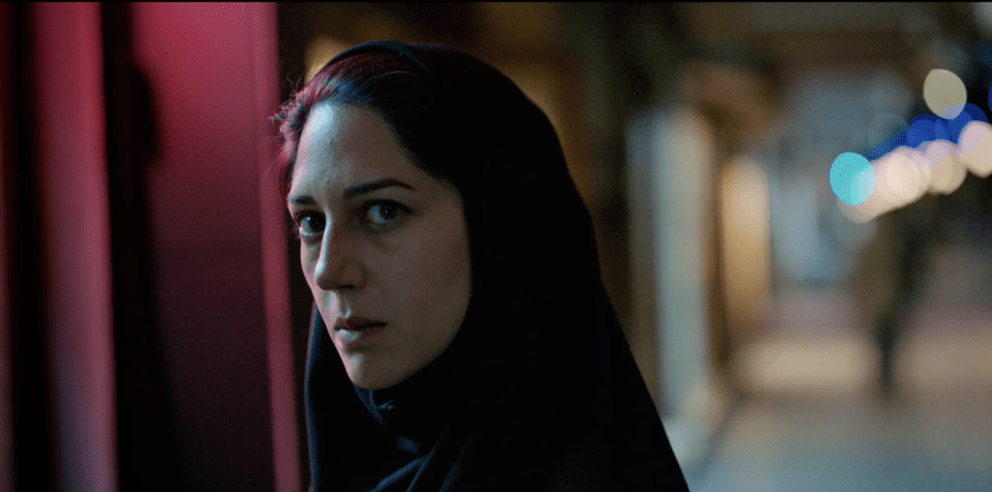 Rahimi, played by Zar Amir-Ebrahimi, looks into the distance. She wears a black headscarf.