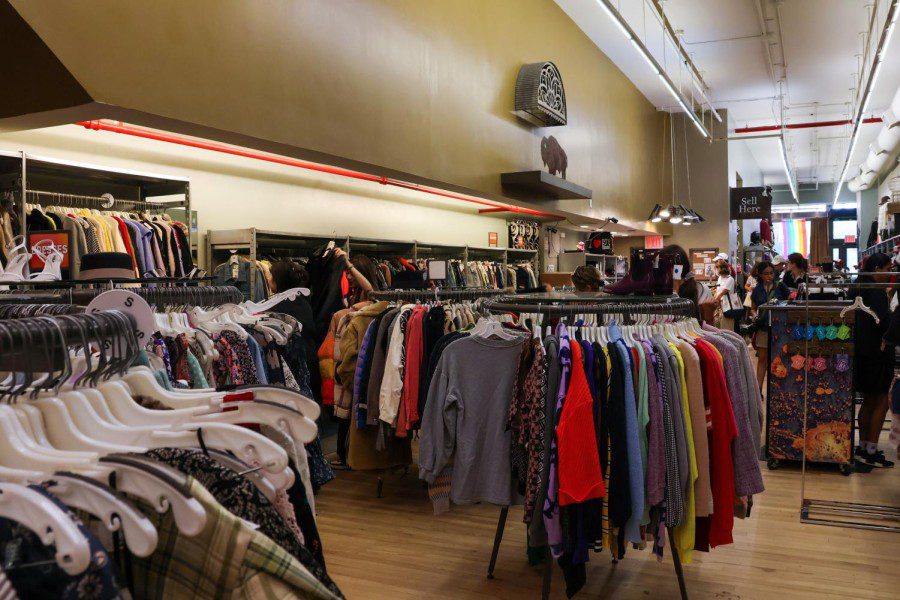 The interior of Buffalo Exchange. Clothes line the inside of the store, both on circular racks and against the wall.