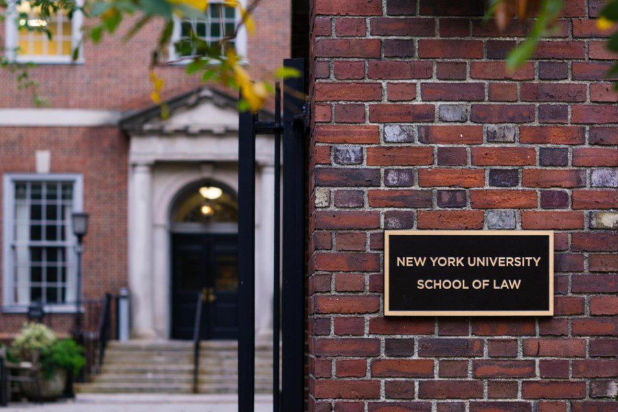 A plaque that reads “New York University School of Law” next to the front gate of N.Y.U.’s law school.