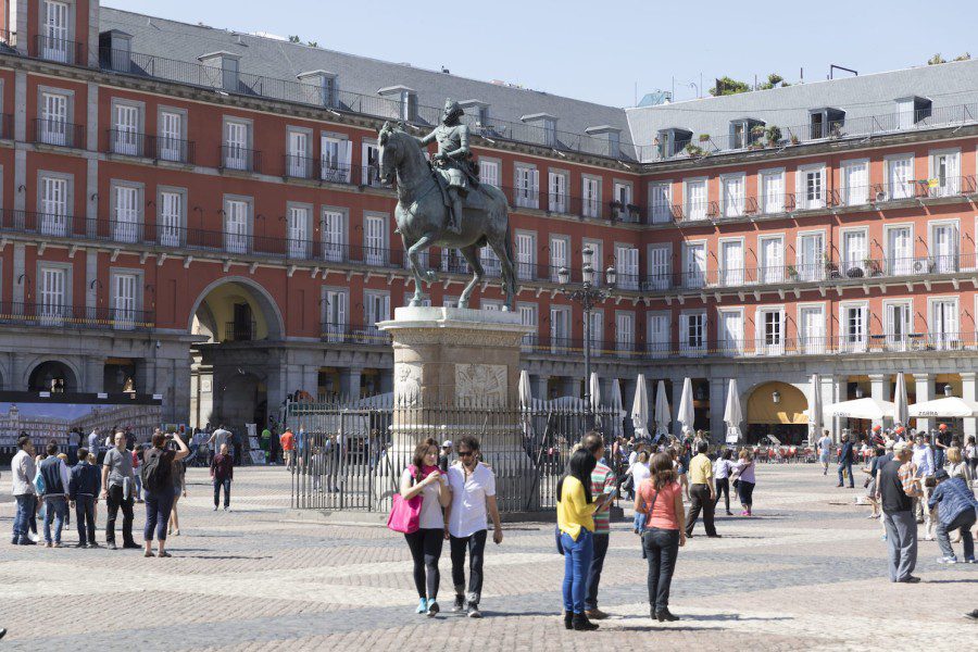 Scattered tourists walking in the Mayor Plaza in Madrid.