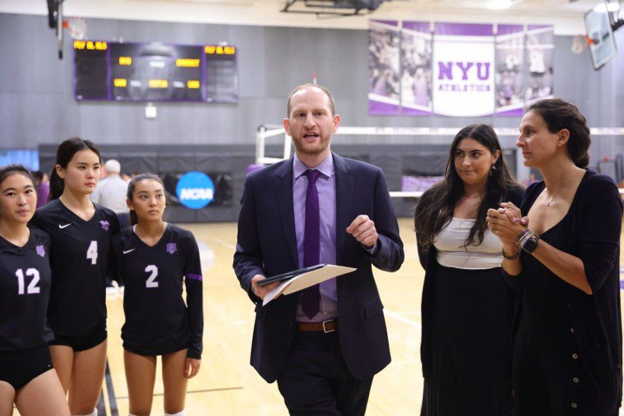 N.Y.U. women’s volleyball head coach Andrew Brown talks to players at a basketball field.