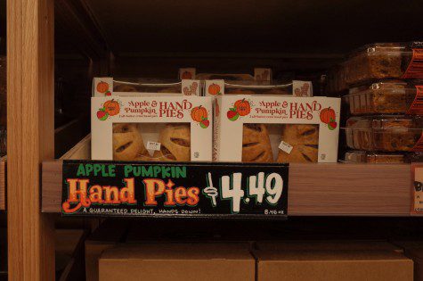 A photo of a shelf tabled “Apple Pumpkin Hand Pies dollar symbol 4.49” with six boxes of Apple Pie on top.