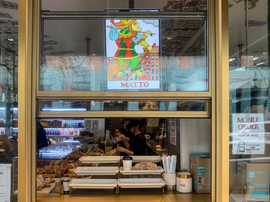A photograph of the Matto Espresso location at Mercer Street. The chain’s logo and a display of food items for sale can be seen through a window.