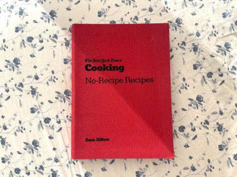 On a white and blue floral background, a book in a red cover with black titles reading "The New York Times Cooking No-Recipe Recipes Sam Sifton."