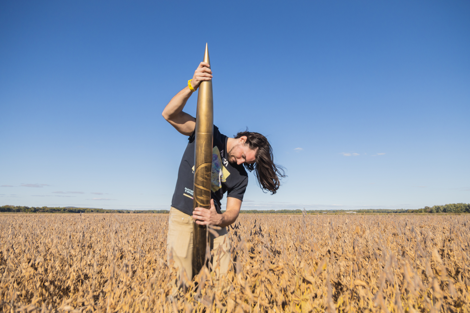 Alex Miller re-assembles his rocket after flight in a wheat field.