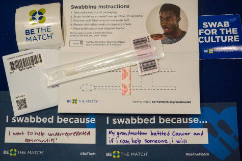 A swabbing kit and two signs below it that read “I swabbed because”.