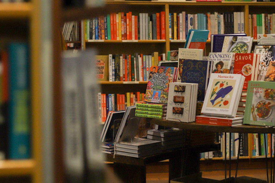 A photograph of a bookshop interior with a bookshelf with titles such as 