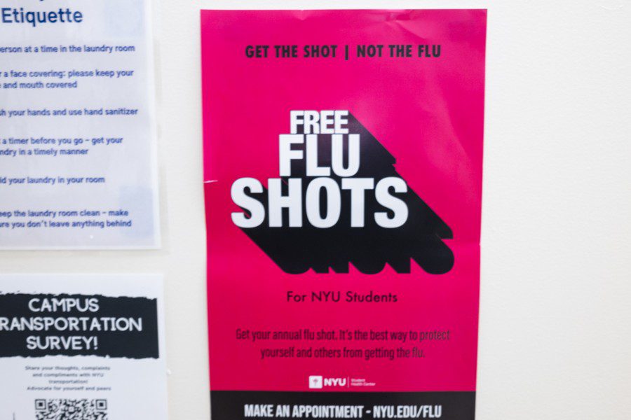 A pink poster posted in Lafayette residence hall that reads "Get the shot | not the flu. Free flu shots for NYU Students."