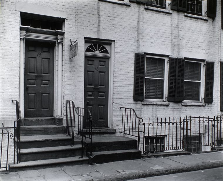 A black and white photograph of the façade of 14 and 16 Gay Street. In front of the town houses is a sidewalk. Railed staircases lead up to the door steps. Adjunct to the doors are two windows.